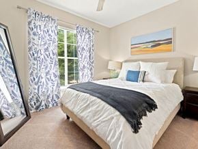 Birmingham apartment for rent - A bedroom with a large bed and a painting of a beach scene on the wall.