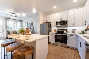 Ocala apartment for rent - A modern kitchen with white cabinets and stainless steel appliances.