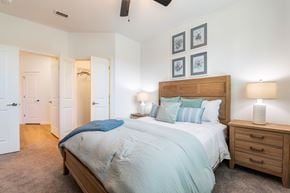 Ocala apartment for rent - A bedroom with a bed, nightstand, and two lamps.