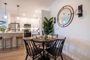 Ocala apartment for rent - A modern dining room with a round mirror and a dining table with chairs.