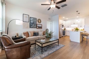 Ocala apartment for rent - A living room with a brown leather chair and a glass coffee table.
