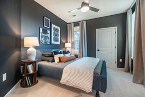 Mooresville apartment for rent - A bedroom with a bed, nightstand, and pictures on the wall at Evolve Lake Norman apartments in Mooresville, NC