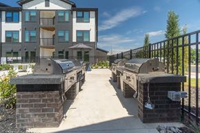 Mooresville apartment for rent - A sunny day at a residential building with a brick BBQ area in front at Evolve Lake Norman apartments in Mooresville, NC