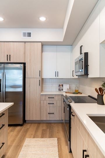 Fort Myers apartment for rent - a kitchen with white cabinets and a stainless steel refrigerator