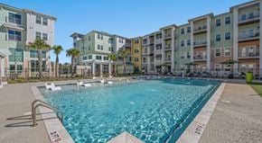 Myrtle Beach apartment for rent - A swimming pool in front of a row of apartment buildings.