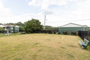 Tuscaloosa apartment for rent - A large grassy field with a bench and a fence.