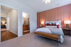 Greensboro apartment for rent - A bedroom with a large bed and a patterned wallpaper.