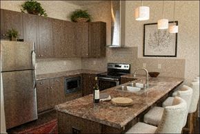 Huntsville apartment for rent - A kitchen with brown cabinets and a granite countertop.
