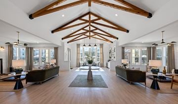 Opelika apartment for rent - A spacious living room with wooden beams on the ceiling and a large rug in the center.