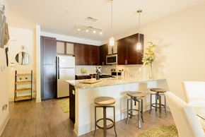 Jamestown apartment for rent - a kitchen with a bar and stools and a refrigerator