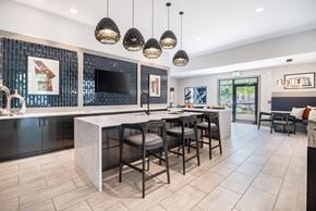 Morrisville apartment for rent - a kitchen with a large island with stools and a dining room with chairs