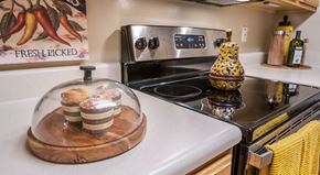 Myrtle Beach apartment for rent - A kitchen with a stove top oven and a wooden tray with food on it at Palmetto Pointe apartments in Myrtle Beach, SC.