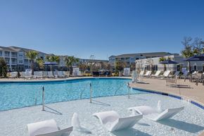 Little River townhouse for rent - a swimming pool with chairs and umbrellas at the resort on a sunny day