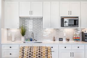 Lake Charles apartment for rent - A kitchen with white cabinets and a brick backsplash.
