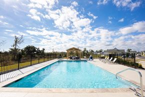 Lake Charles apartment for rent - A large outdoor swimming pool surrounded by a black fence.