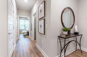 Greensboro apartment for rent - a hallway with framed pictures and a mirror and a door to a bedroom