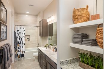 Floor-to-ceiling tiling in bathrooms with built-in tub/shower niches and rain shower heads