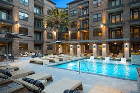 Houston apartment for rent - A large apartment building with a pool in front at 27Seventy Lower Heights apartments in Houston, TX.
