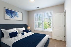 Greensboro apartment for rent - A bedroom with a large bed and a blue abstract painting on the wall.