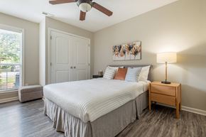 Raleigh apartment for rent - a bedroom with a large bed and a ceiling fan
