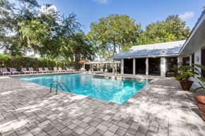 Savannah apartment for rent - A pool surrounded by trees and a building.