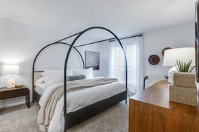 Savannah apartment for rent - A bedroom with a canopy bed and a wooden dresser.