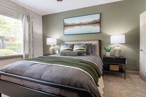 Ooltewah apartment for rent - A bedroom with a large bed and a painting on the wall.