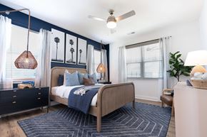 Leland apartment for rent - A bedroom with a bed, nightstand, and a ceiling fan.