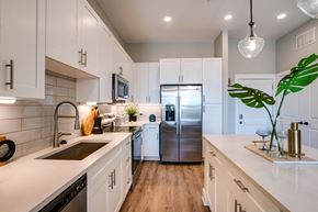 Raleigh apartment for rent - a kitchen with white cabinets and a stainless steel refrigerator