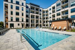 Raleigh apartment for rent - an apartment swimming pool in front of an apartment building
