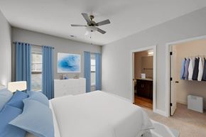 Greenville townhouse for rent - A bedroom with a white bed and blue curtains.