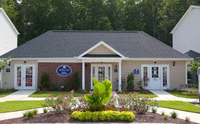 Fayetteville apartment for rent - Exterior building with a blue sign in front of it and name of the property.