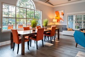 Charlotte apartment for rent - a living room with a large window and a wooden table with orange chairs