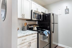 Charlotte apartment for rent - a kitchen with white cabinets and black appliances