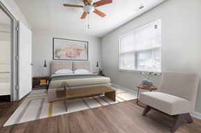 Raleigh apartment for rent - A bedroom with a bed, chair, and a ceiling fan.