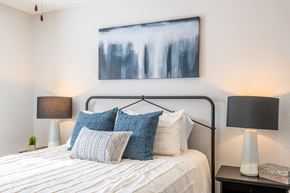 Spring Lake apartment for rent - a bedroom with a bed with pillows and a painting on the wall