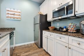 Columbia apartment for rent - A kitchen with a black refrigerator and white cabinets.