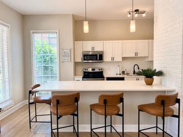 Knoxville apartment for rent - A kitchen with a white counter and brown chairs.