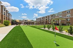 Spartanburg apartment for rent - a green lawn in front of an apartment complex with a flag in the grass