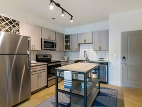 New Bern apartment for rent - a kitchen with stainless steel appliances and a wooden table