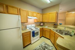 Columbia apartment for rent - A kitchen with wooden cabinets and a white refrigerator.