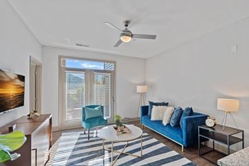 Asheville apartment for rent - A living room with a blue couch and a ceiling fan.