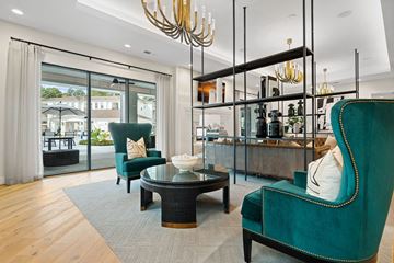 Pinehurst apartment for rent - a living room with green chairs and a bar and glass doors