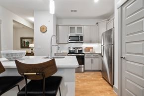 Asheville apartment for rent - A modern kitchen with a wooden chair and a white countertop.