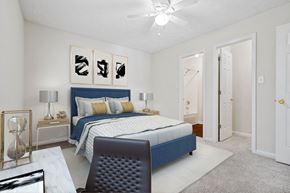 Fayetteville apartment for rent - A bedroom with a bed, nightstand, and desk and chair.