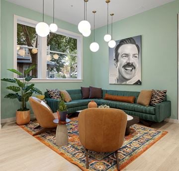 Charlotte apartment for rent - a living room with a green couch and chairs and a painting on the wall