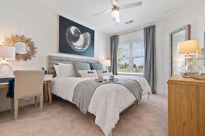 Cape Coral apartment for rent - A bedroom with a large bed, a desk, and a ceiling fan.