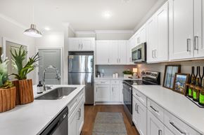 Hope Mills apartment for rent - A modern kitchen with white cabinets and stainless steel appliances.