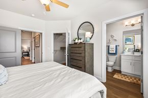 Hope Mills apartment for rent - A bedroom with a large bed and a mirror on the wall.