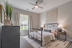 Raleigh apartment for rent - a bedroom with a bed and a ceiling fan